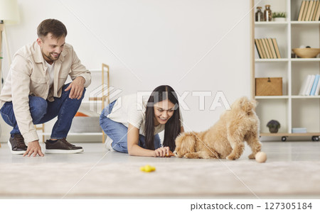 Family Couple Training And Playing With Dog At Home 127305184