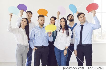 Team of several business men and women holding empty colorful paper speech bubbles Team of several business men and women holding empty colorful paper speech bubbles 127305260