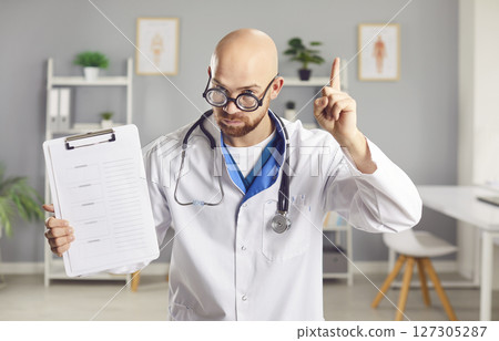 Portrait of a Serious Doctor or Nurse in Funny Glasses Holding a Tablet 127305287
