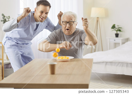 Caregiver Playing A Ball Game With Elderly Man At Nursing Home 127305343