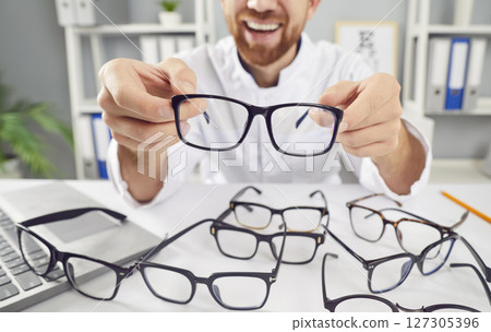 Close Up Of Positive Ophthalmologist Showing Eyeglasses In Office 127305396