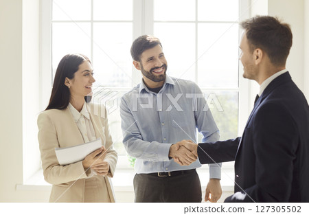Colleagues Shaking Hands After Successful Partnership Deal In Office 127305502