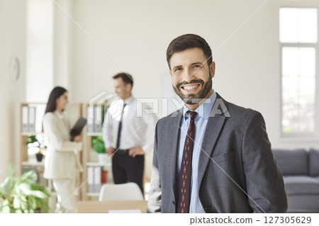 Businessman smiling confident, male leader and diverse employees gathered brainstorming together Businessman smiling confident, male leader and diverse employees gathered brainstorming together 127305629
