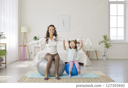 Happy sporty playful funny active family on fitness ball, mother parent, babysitter, small child 127305692