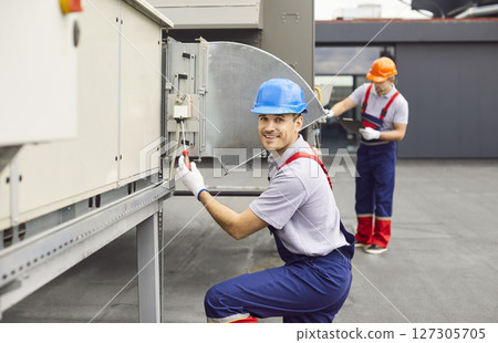 Portrait Of Electrician Conducting Maintenance And Repair On Hvac System On Roof 127305705
