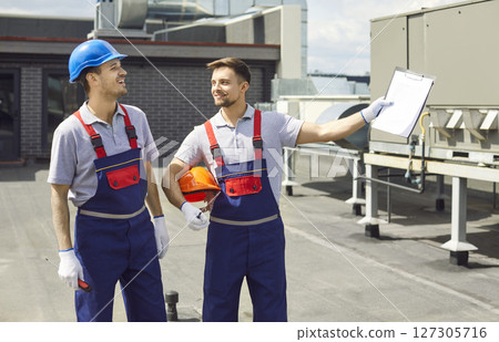 Repairmen Inspecting Hvac And Ventilation Systems On Roof Repairmen Inspecting Hvac And Ventilation Systems On Roof 127305716