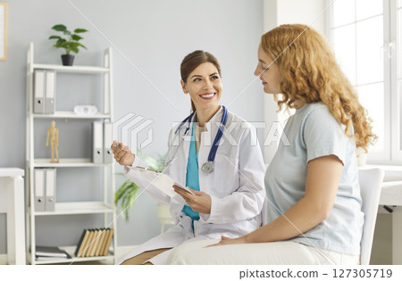 Happy attentive female therapist professional consulting woman client in office, female health 127305719