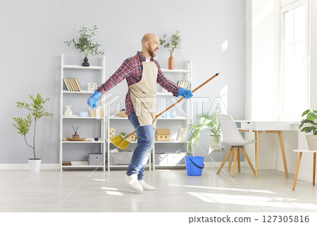Happy Man Dancing With Broom While Cleaning At Home Happy Man Dancing With Broom While Cleaning At Home 127305816