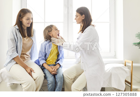 Dentist Or Nurse Performing Oral Examination On Boy Patient At Hospital Dentist Or Nurse Performing Oral Examination On Boy Patient At Hospital 127305888