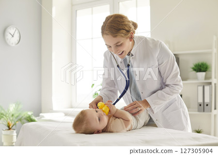 Pediatrician Using Stethoscope To Examine Baby Lungs At Clinic Pediatrician Using Stethoscope To Examine Baby Lungs At Clinic 127305904