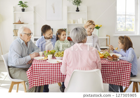 Happy family gathering union meal at home, grandparents, mother, father with two small children Happy family gathering union meal at home, grandparents, mother, father with two small children 127305905