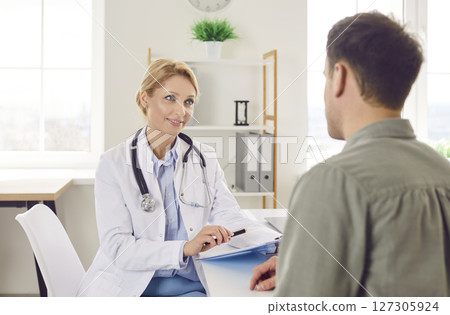 Male Patient Receiving Medical Consultation From Doctor Or Nurse 127305924