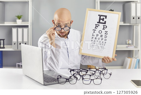 Portrait Of Funny Ophthalmologist Doctor With Eyeglasses And Eye Chart Portrait Of Funny Ophthalmologist Doctor With Eyeglasses And Eye Chart 127305926