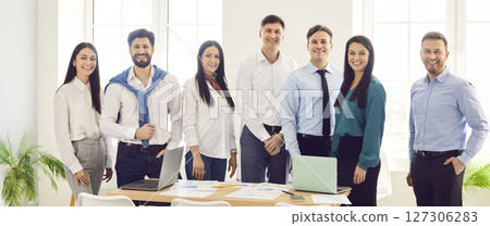 Portrait of business people men and women looking at camera and smiling in office after a meeting. Portrait of business people men and women looking at camera and smiling in office after a meeting. 127306283