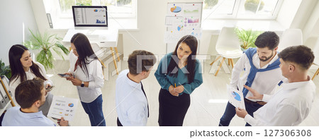 Group of young confident business people men and women talking in office during a meeting. 127306308