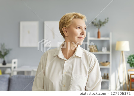 Portrait of mature elderly woman wearing casual clothes looking to the side standing at home. 127306371