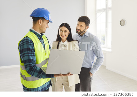 Family Couple Reviewing Home Renovation Blueprint With Contractor 127306395