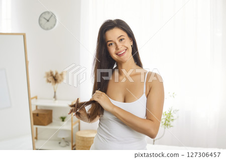 Happy morning home care, beautiful female looking in mirror doing beauty procedures, combing Happy morning home care, beautiful female looking in mirror doing beauty procedures, combing 127306457