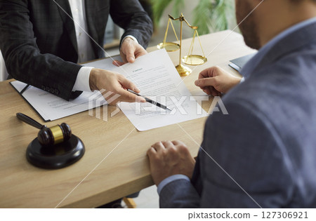 Close-Up Of Lawyer And Client Discussing Contract Close-Up Of Lawyer And Client Discussing Contract 127306921
