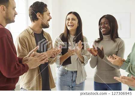 Positive mixed race women and men friends glad to meet together, standing in circle and applauding Positive mixed race women and men friends glad to meet together, standing in circle and applauding 127306945