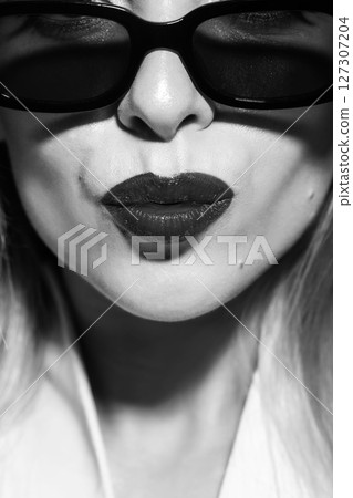 Beautiful woman close-up studio portrait with sunglasses sending kiss 127307204