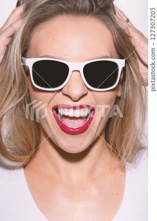 Beautiful woman close-up studio portrait with white sunglasses and red lipstick Beautiful woman close-up studio portrait with white sunglasses and red lipstick 127307205
