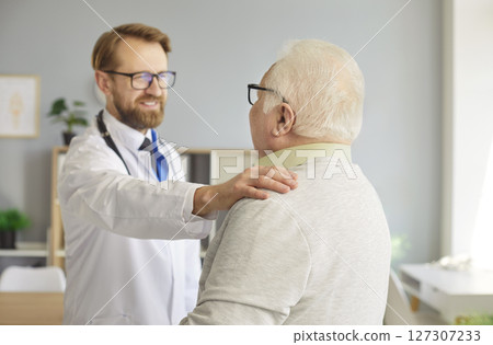 Male physician or nurse support his senior patient standing in medical clinic. Male physician or nurse support his senior patient standing in medical clinic. 127307233