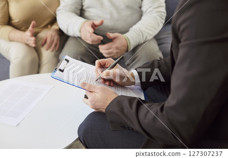 Lawyer manager in formal attire writing down in documents, preparing insurance contract  127307237