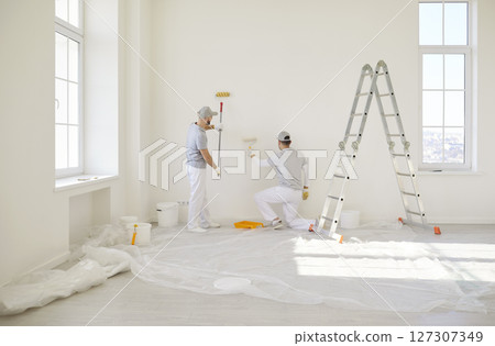 Painters team wall painting, construction workers, professional service near stepladder Painters team wall painting, construction workers, professional service near stepladder 127307349