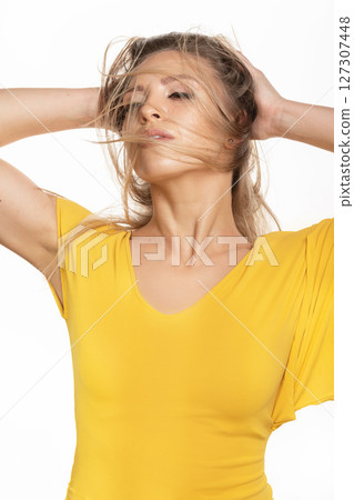Beautiful woman with yellow dress studio portrait in white background 127307448