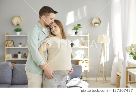 Loving couple gentle feeling of fondness future parents expecting first baby close at home, caring  127307457