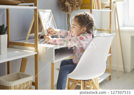 Small little girl playing, learning at home sitting in own room, happy baby and children furniture 127307531