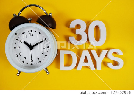 30 Days alphabet letters with alarm clock on yellow background 30 Days alphabet letters with alarm clock on yellow background 127307996