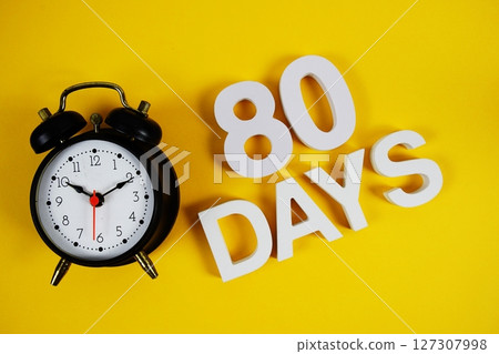80 Days alphabet letters with alarm clock on yellow background 127307998