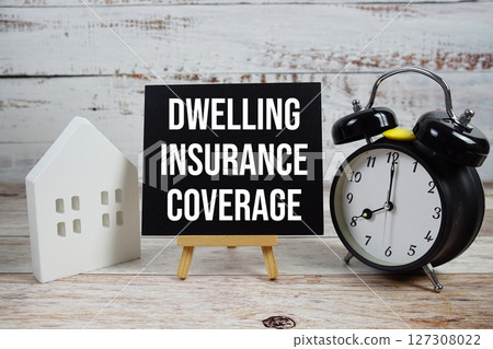 Dwelling Insurance Coverage on paper card with white house model, and alarm clock on wooden background Dwelling Insurance Coverage on paper card with white house model, and alarm clock on wooden background 127308022