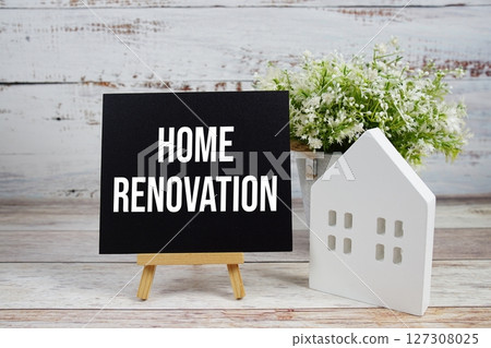 Home Renovation on paper card with white house model on wooden background Home Renovation on paper card with white house model on wooden background 127308025