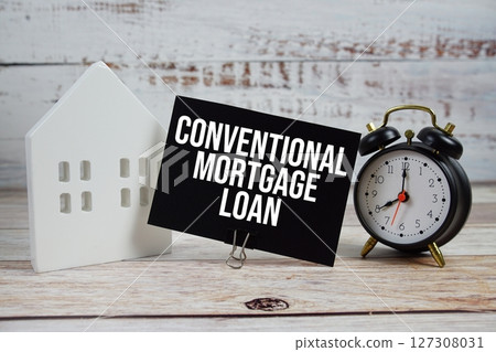 Conventional Mortgage Loan on paper card with alarm clock and white house model on wooden background 127308031