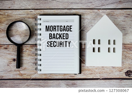 Mortgage-backed Security text on paper notebook with white house model and magnifying glass on wood background 127308067