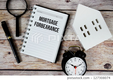 Mortgage Forbearance text on paper notebook with white house model and magnifying glass on wood background Mortgage Forbearance text on paper notebook with white house model and magnifying glass on wood background 127308074