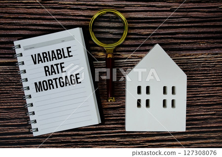Variable Rate Mortgage text on paper notebook with white house model and magnifying glass on wood background Variable Rate Mortgage text on paper notebook with white house model and magnifying glass on wood background 127308076