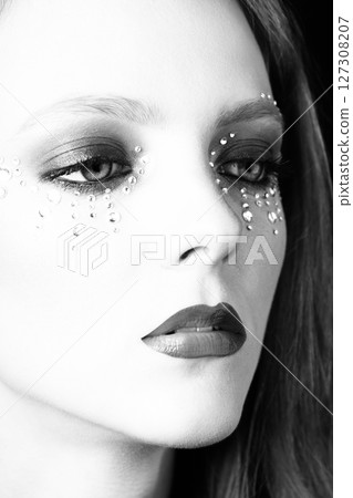 Beautiful woman portrait with glued jewelry on her face 127308207