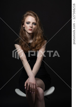 Beautiful woman studio portrait in black background 127308216