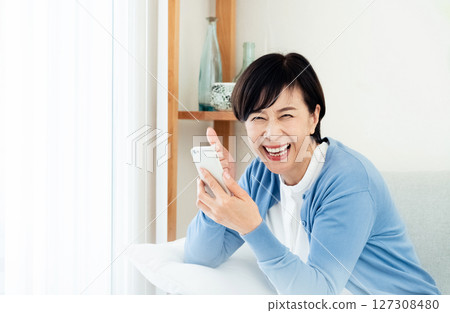 Middle-aged woman making a video call on a smartphone 127308480