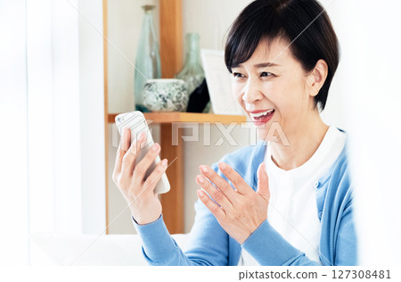 Middle-aged woman making a video call on a smartphone 127308481