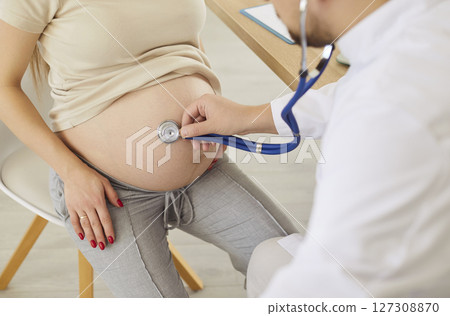 Close up of pregnant woman visiting doctor in clinic, medical gynecologist examines fetal heartbeat Close up of pregnant woman visiting doctor in clinic, medical gynecologist examines fetal heartbeat 127308870