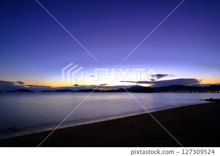 A quiet beach at dusk where only the sound of the waves can be heard 127309524