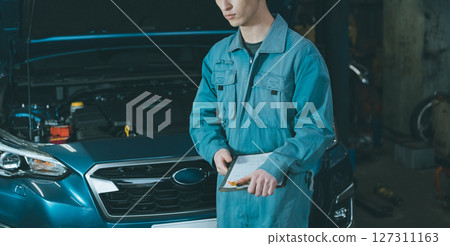 Auto mechanic inspecting engine compartment 127311163