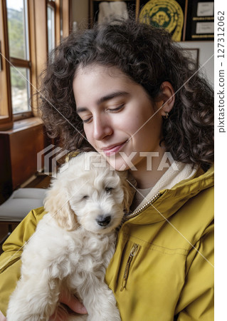Young woman holding a fluffy puppy in a cozy veterinary clinic with warm wooden accents Young woman holding a fluffy puppy in a cozy veterinary clinic with warm wooden accents 127312062