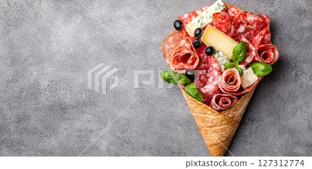 stunning charcuterie cone filled with cured meats, cheese, and herbs 127312774