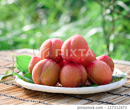 Plums with shining water droplets and a bamboo basket Image of summer fruits (early) 127312873